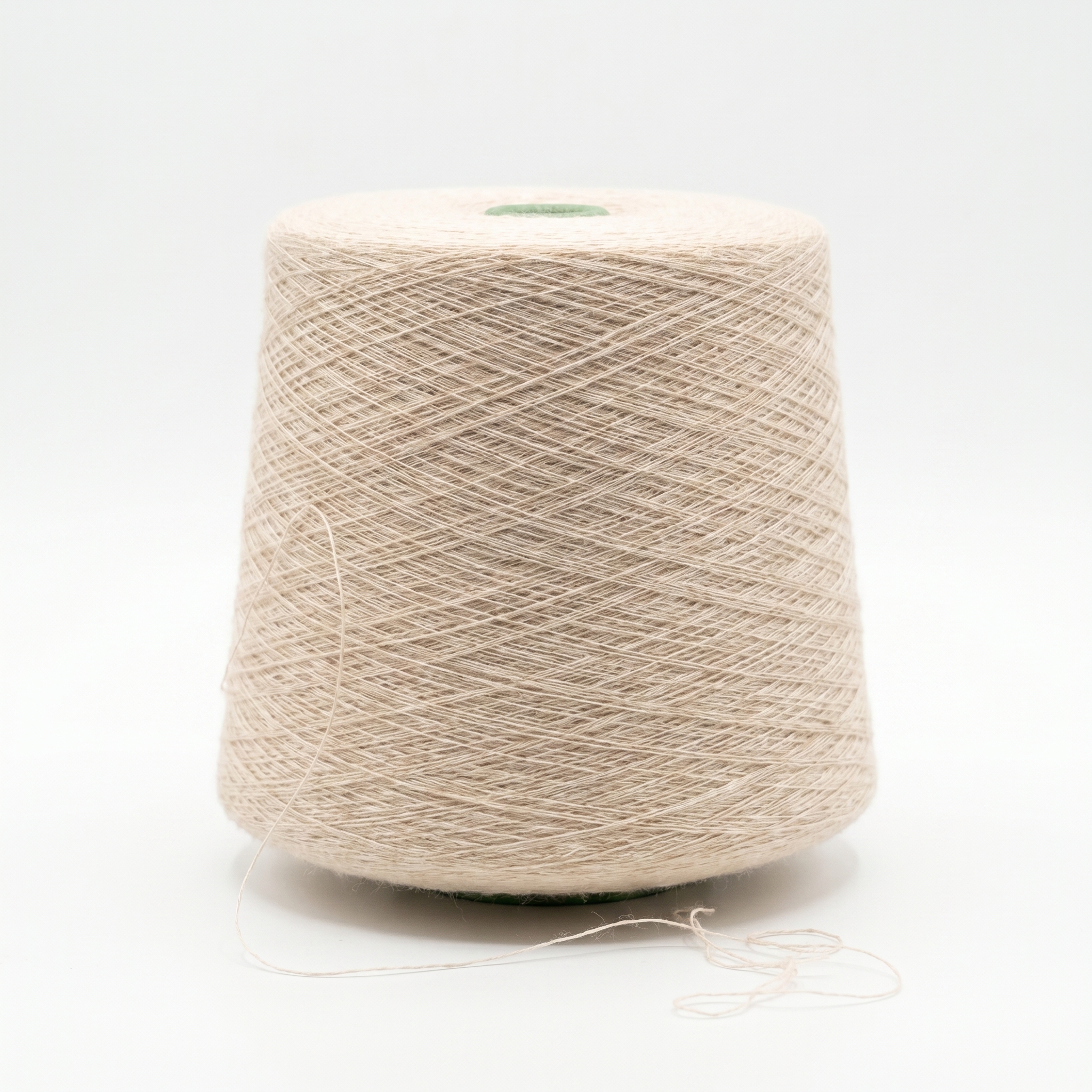 En stor spole med lyst beige garn på en hvit bakgrunn.