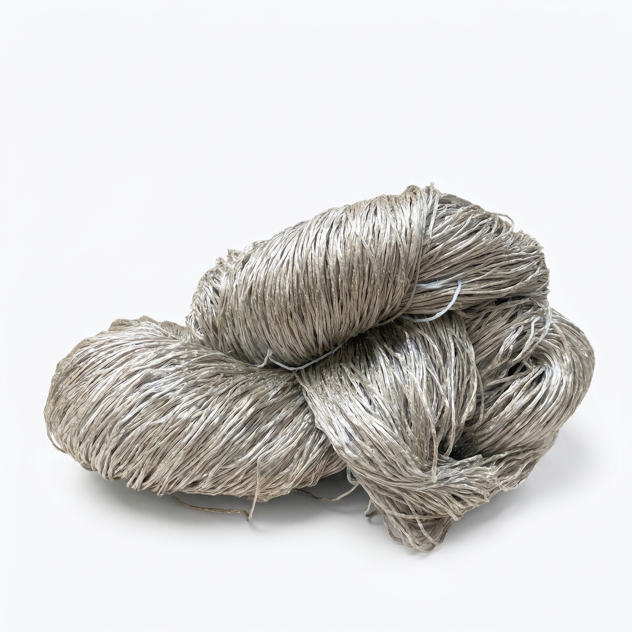 En stor, løs bunt med gråbeige fibrøst materiale på hvit bakgrunn.