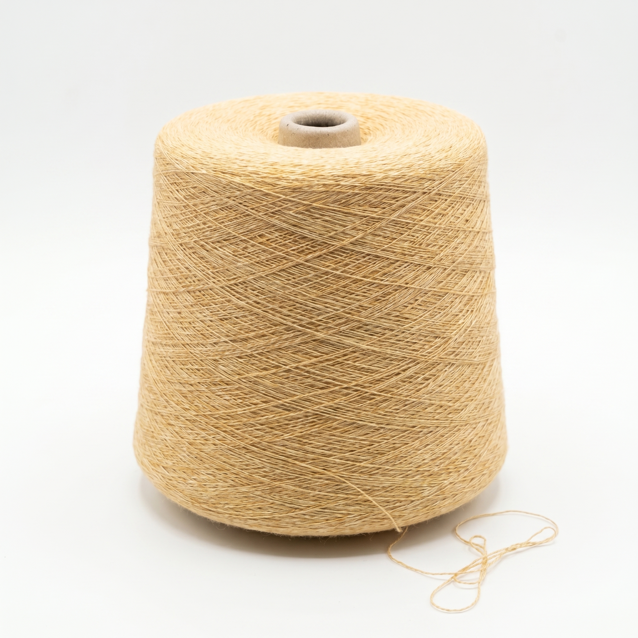 En spole med lyst beige, teksturert garn på en hvit bakgrunn.