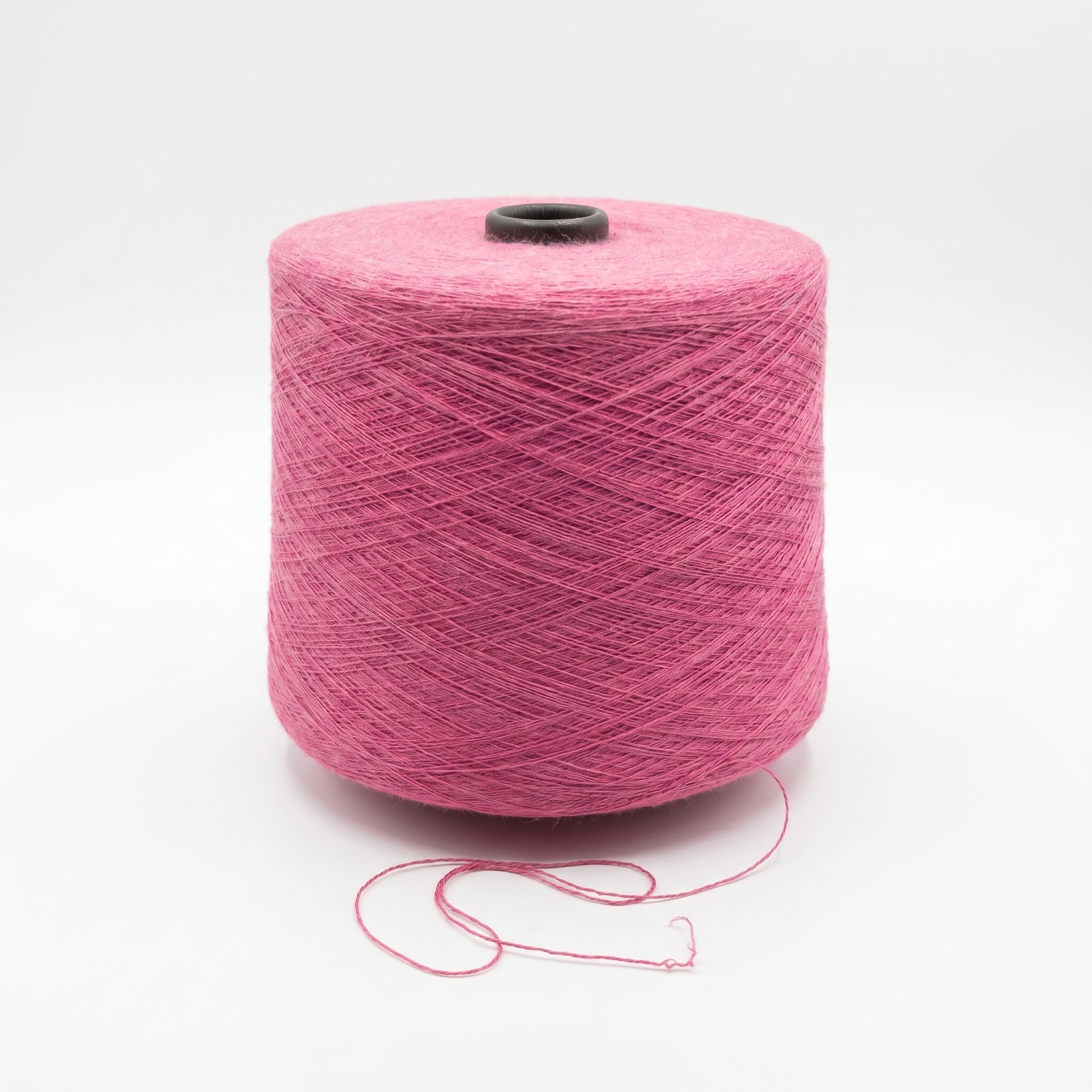 En spole med rosa garn på en hvit bakgrunn.