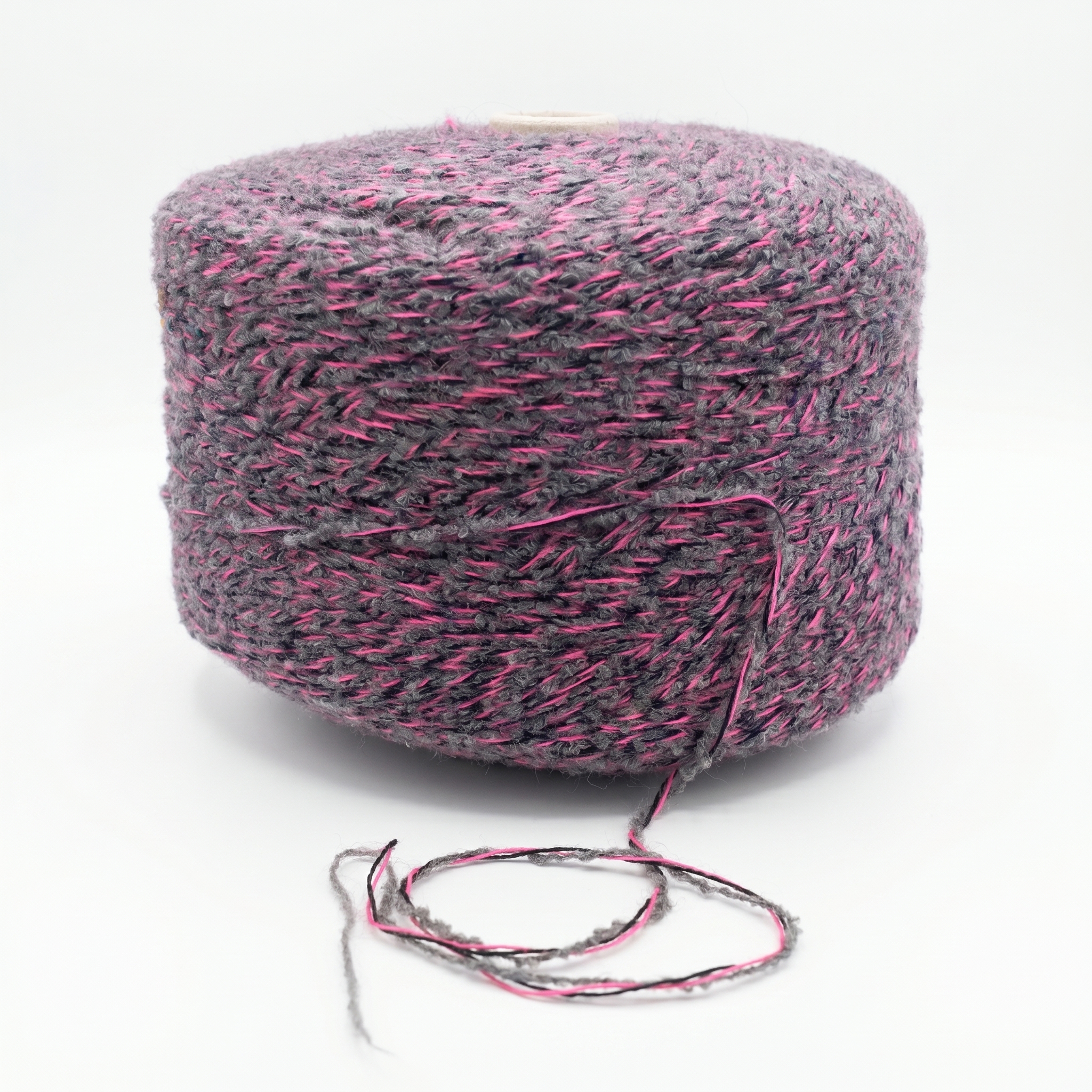 En spole av grått og rosa strukturert garn med en løs tråd.