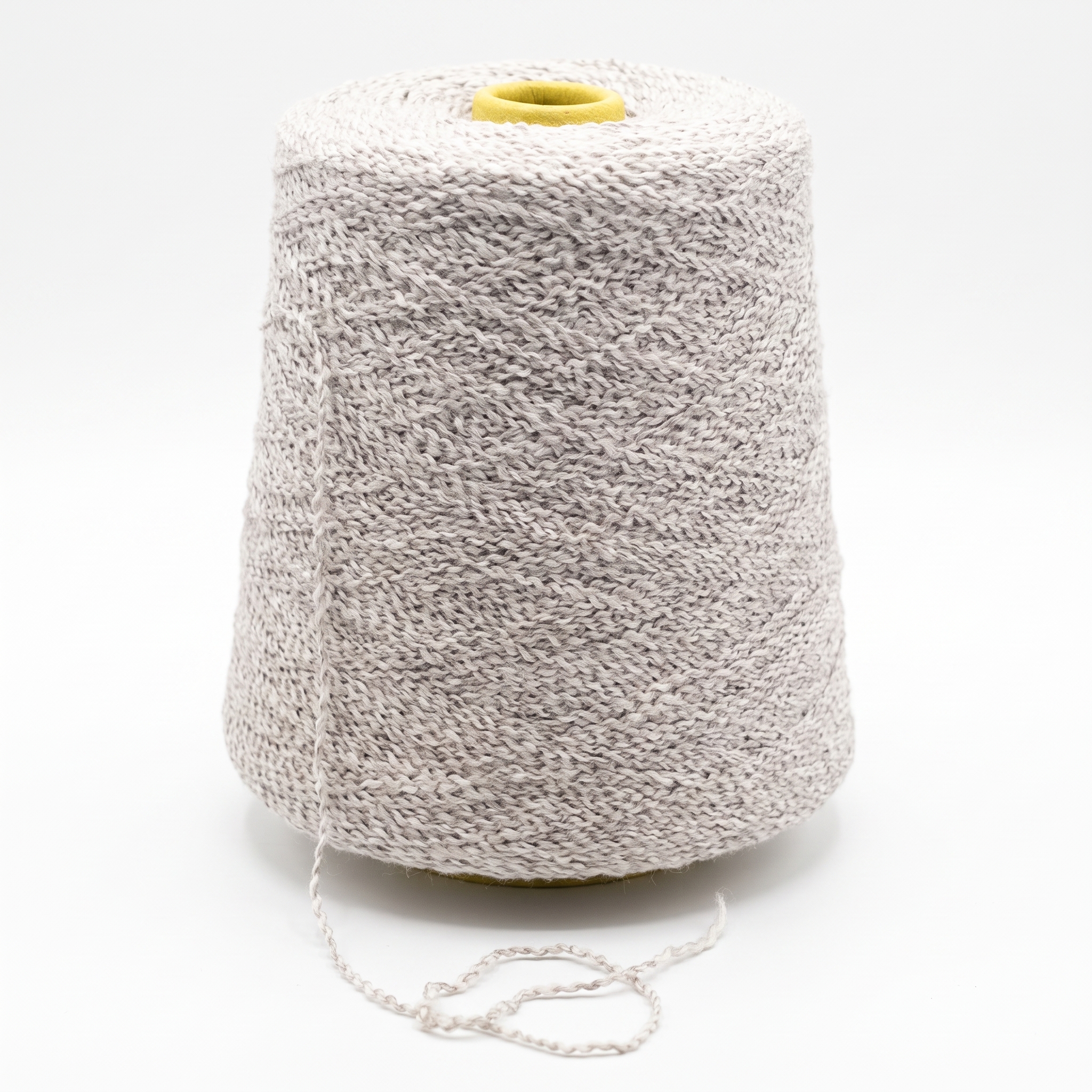 En stor spole med lyst, teksturert garn, med en løs tråd og en gul topp, på hvit bakgrunn.