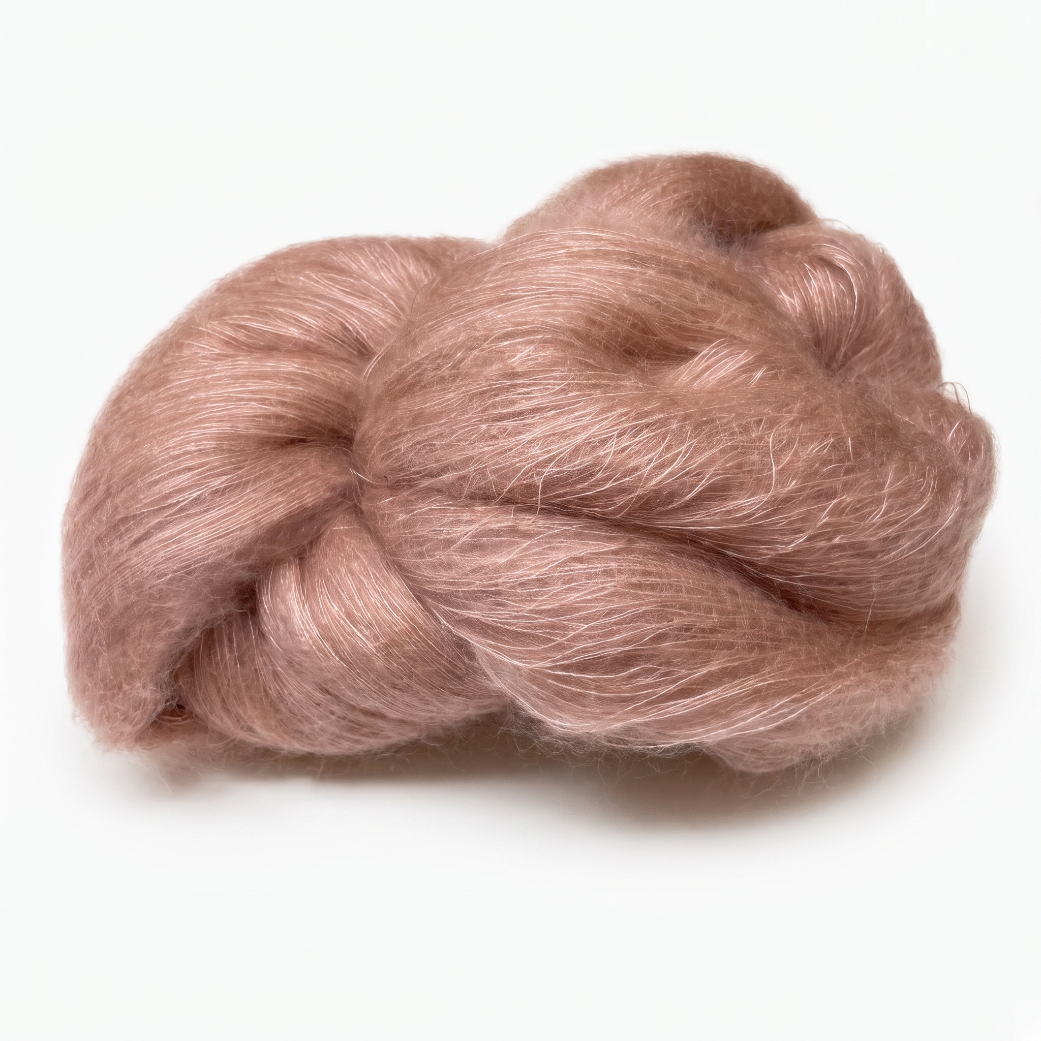Et nøste med mykt, loddent, rosa-brunt garn på en hvit bakgrunn.