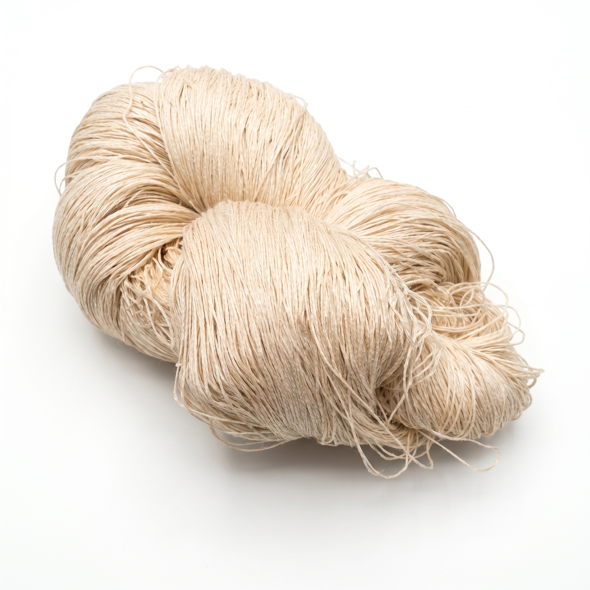En stor hespe med lyst beige garn ligger på en hvit overflate.