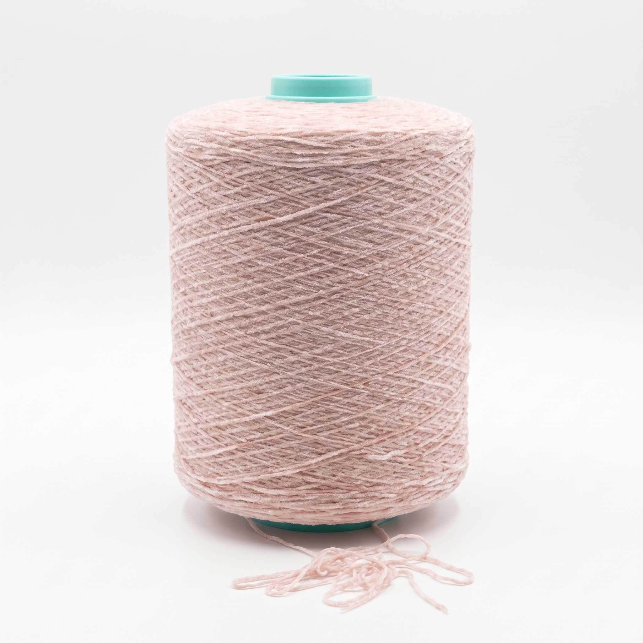 En stor spole med rosa garn på et turkis plastrør, med litt løst garn nederst.
