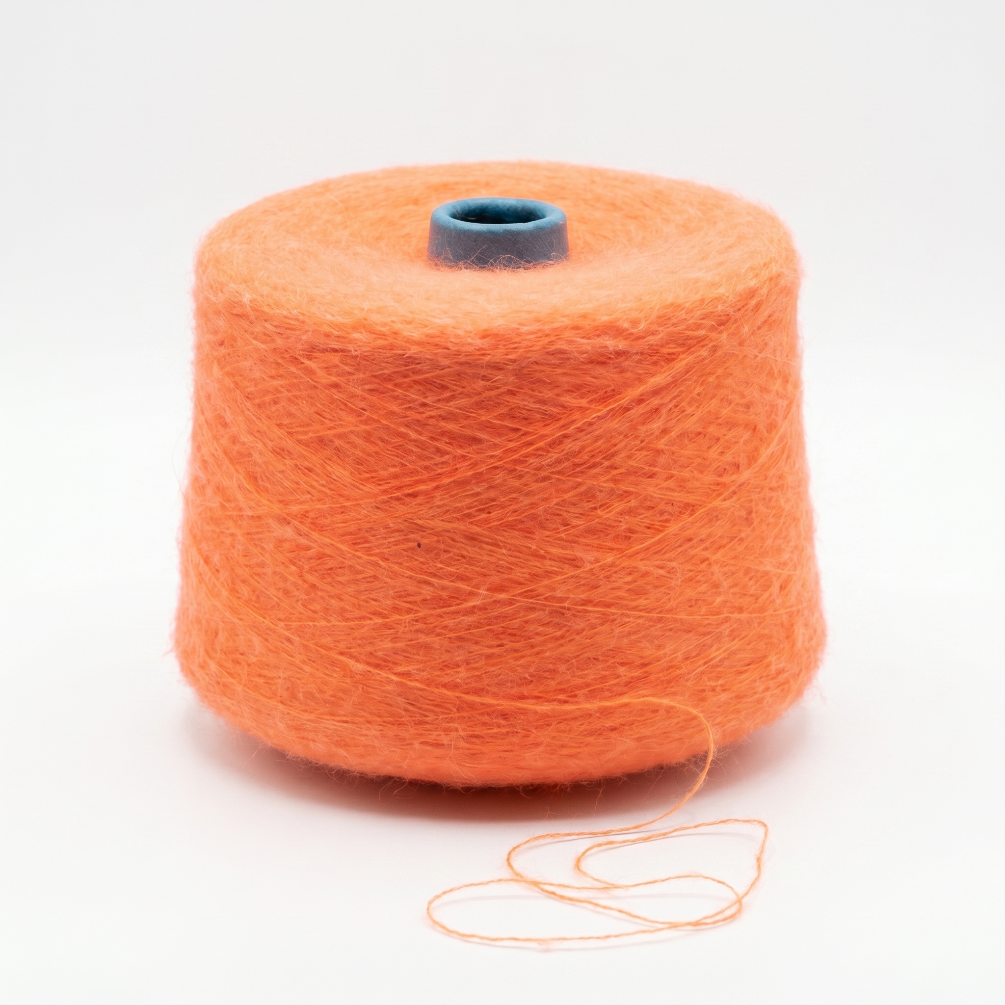 En stor spole med loddent, oransje garn og en synlig blå kjerne i toppen.