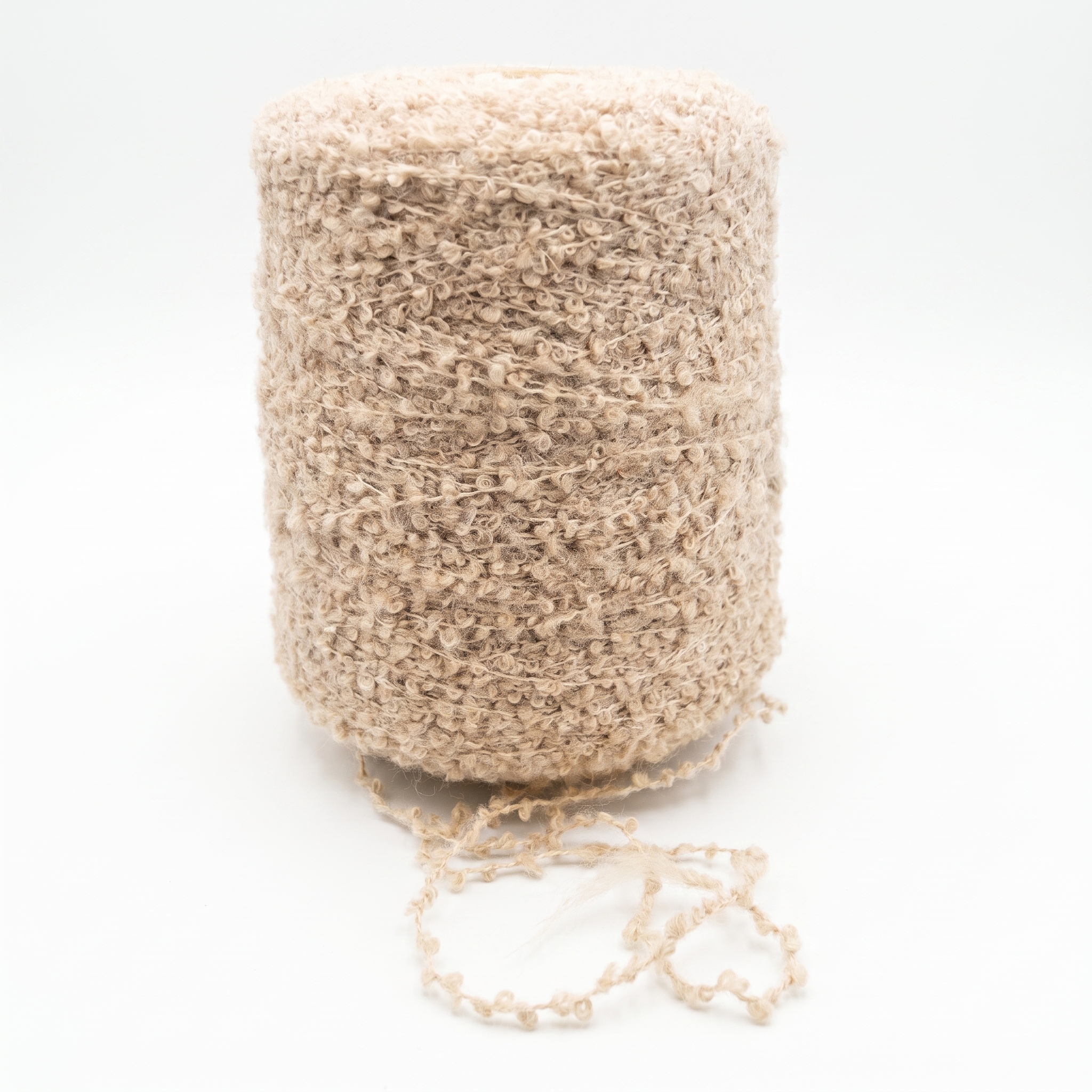 En spole med lys beige, strukturert bouclégarn og en løs tråd i bunnen.