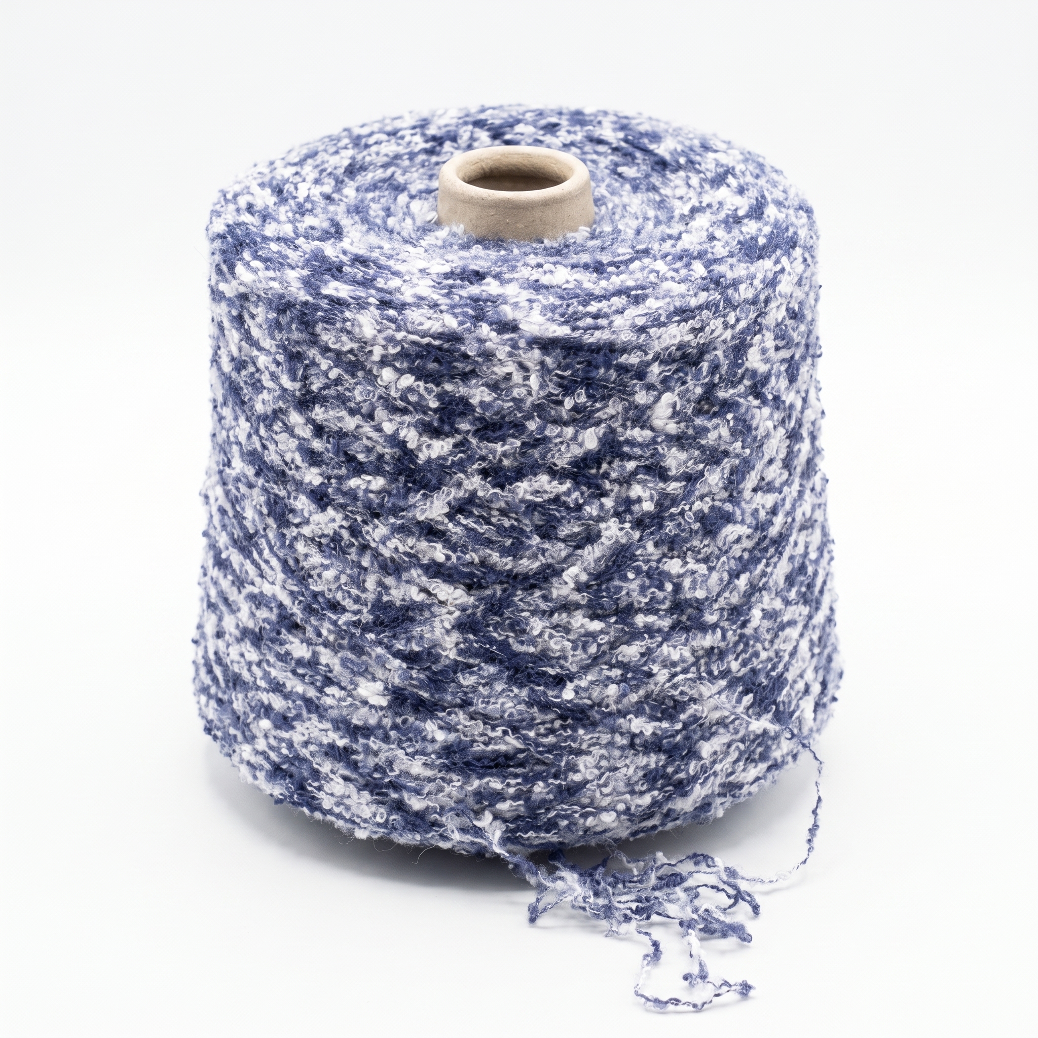 En stor spole med blått og hvitt bouclé-garn på hvit bakgrunn.