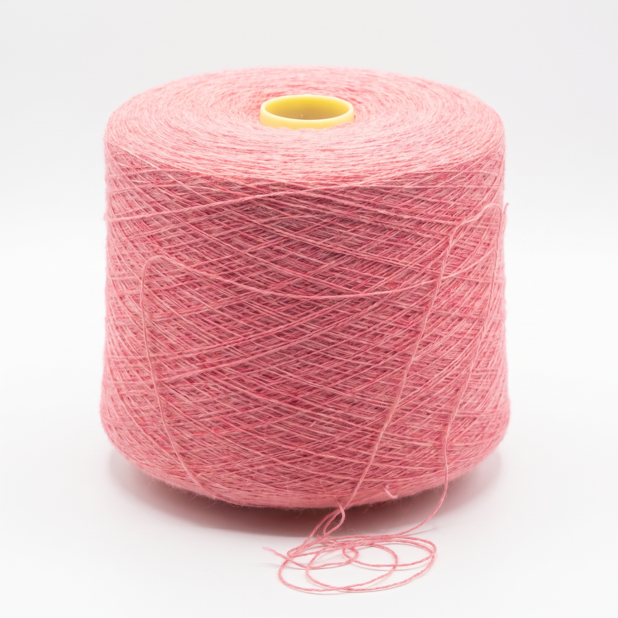 En stor spole med rosa garn på hvit bakgrunn.