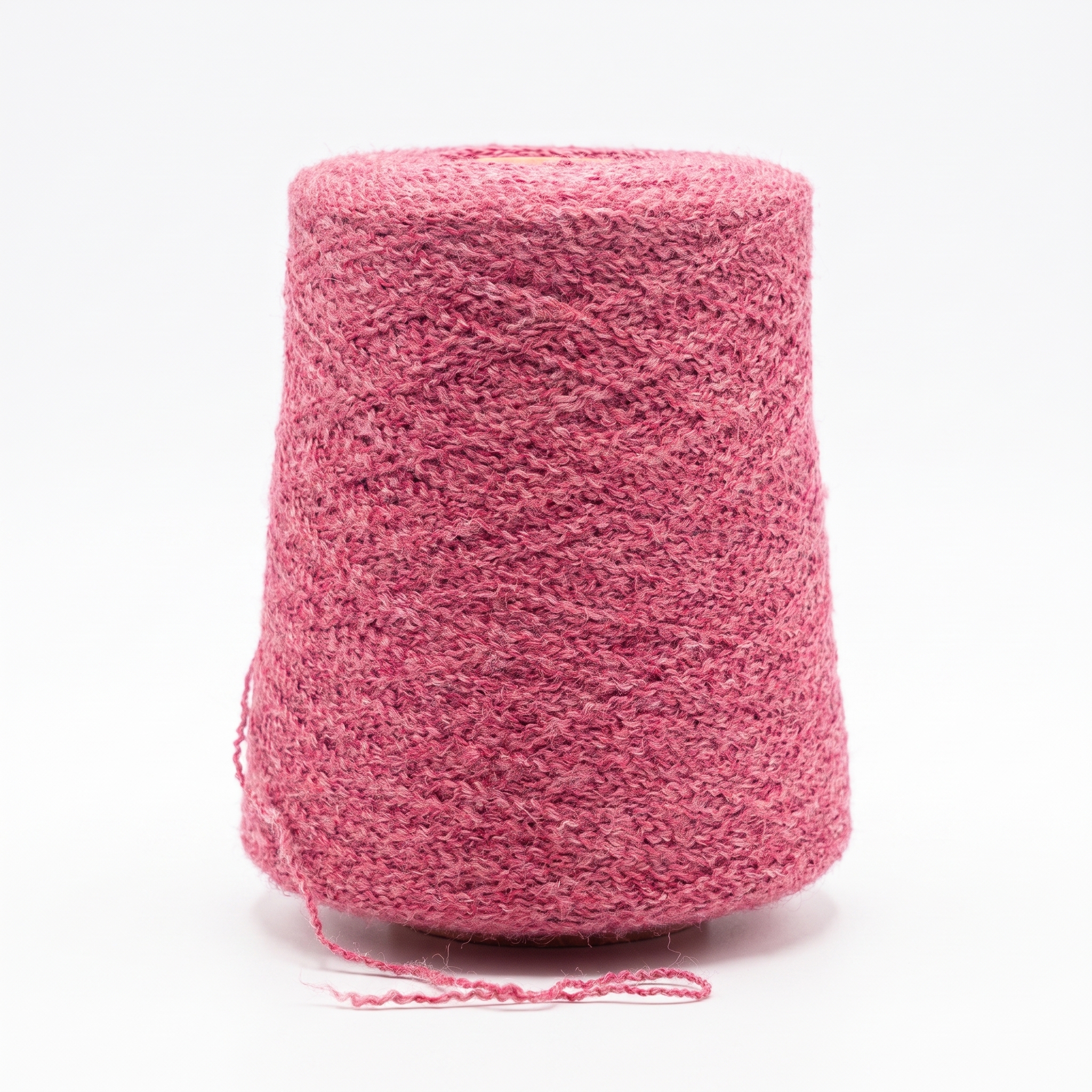 En stor spole med strukturert rosa garn på en hvit bakgrunn.