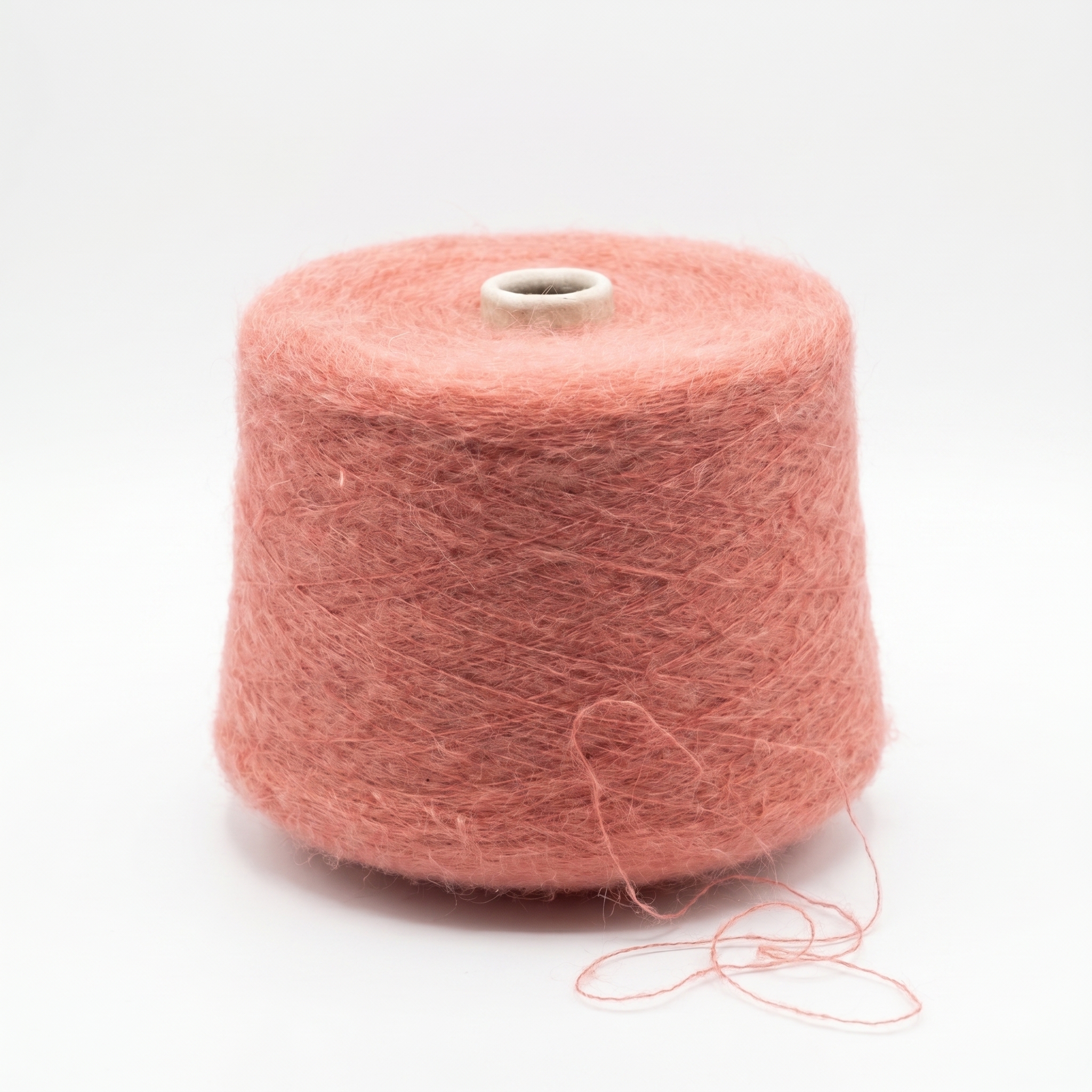 En stor spole viklet med loddent, rosa garn.