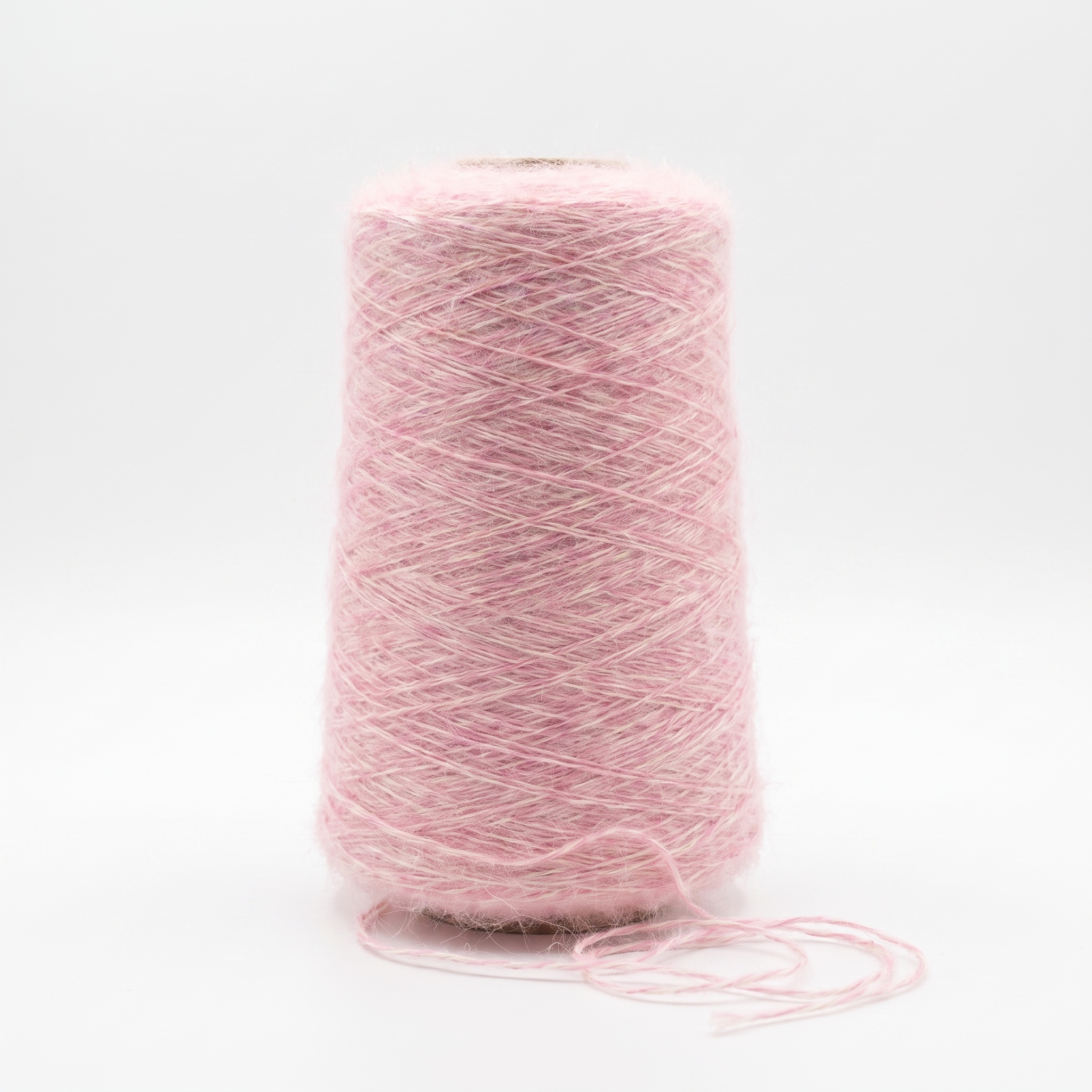 En spole med loddent rosa garn på en hvit bakgrunn.